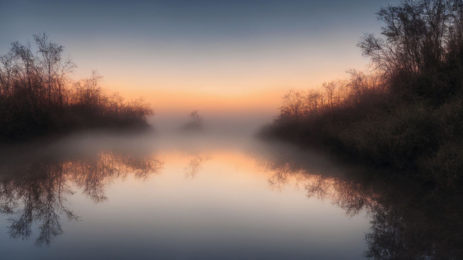 Mist lifting over still water at dawn